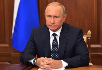 Poetin achter bureau tijdens de toespraak